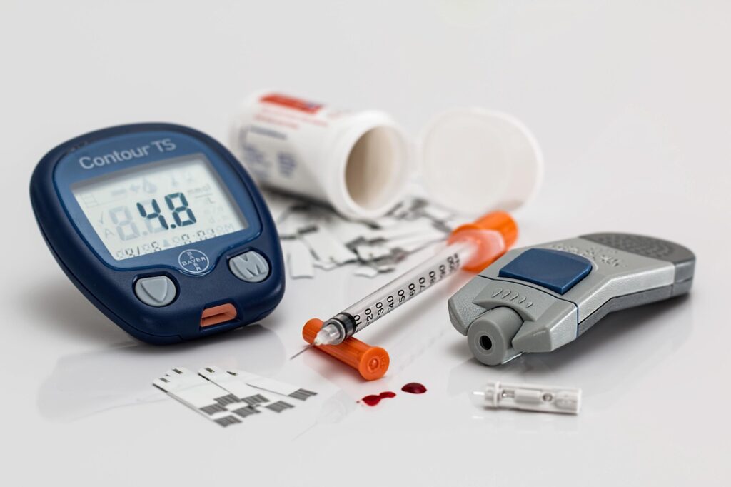 Insulin syringe and glucometer placed on a table for diabetes blood glucose monitoring